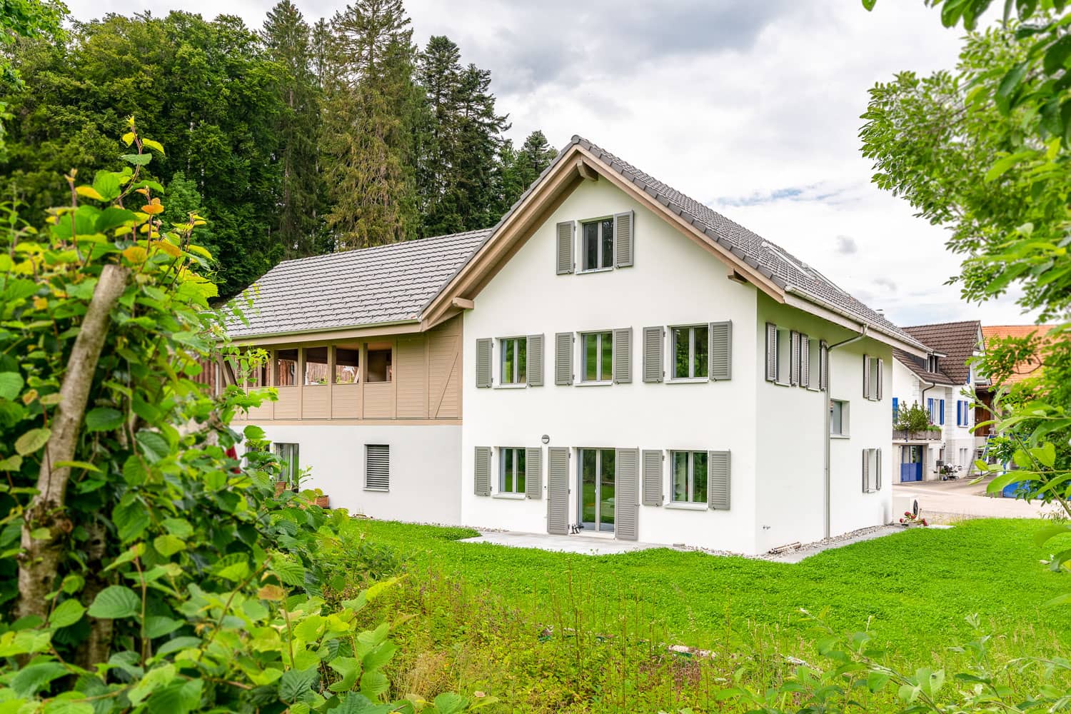 Haus mit Satteldach und grüner Wiese